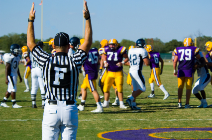 American Football played by young men scoriing a touchdown signaled by game official